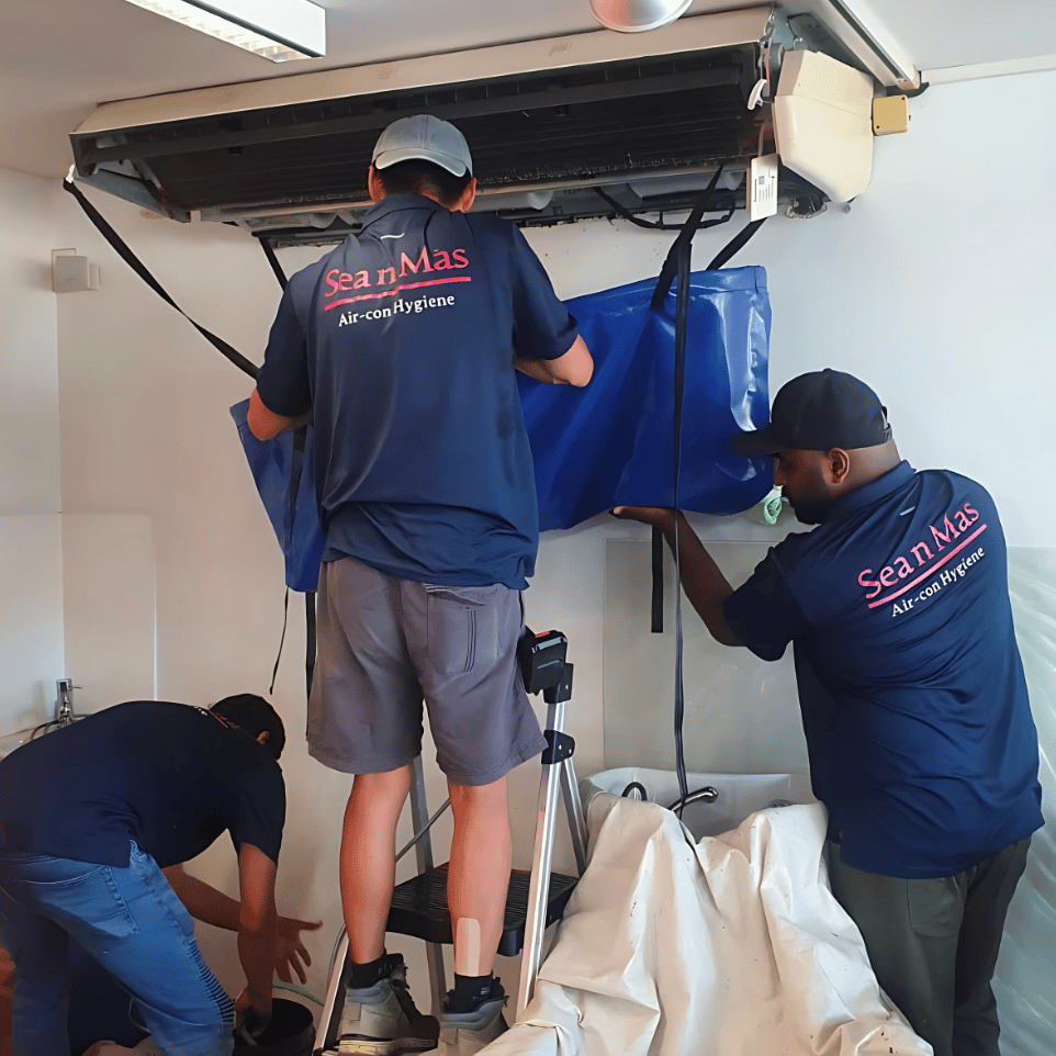 Two Sea n Mas technicians cleaning a ceiling cassette aircon