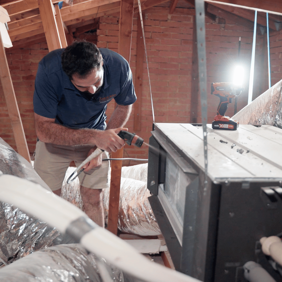echnician cleaning an aircon indoors