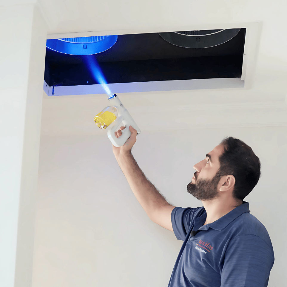 Technician cleaning a wall-mounted split system aircon