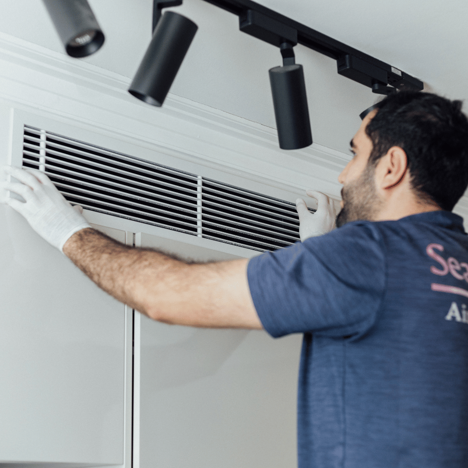 Sea n Mas technician cleaning a ceiling cassette aircon